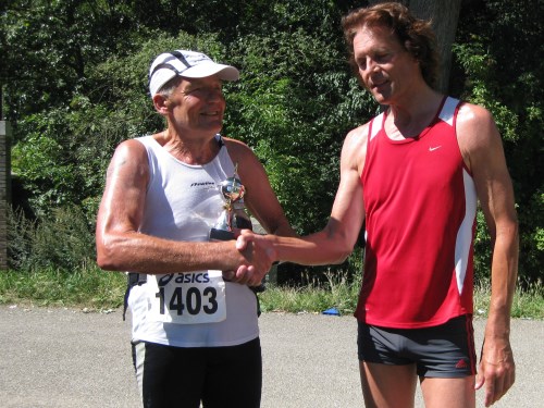 Gijs Honing ontvangt tijdens de Bosbaan Marathon 2012 een beker ter ere van zijn 600ste marathon.